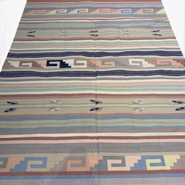 A versatile and beautifully crafted handwoven Durrie kilim rug, made in India, featuring a timeless striped composition...