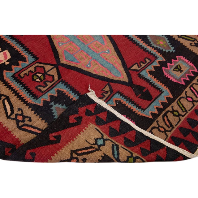 Beautiful vintage Turkish Kilim hand-knotted wool rug with a black field. This piece has a tan frame and multicolor...