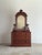 Antique walnut dresser with an arched mirror and carved crest, the surface showing rich, warm brown tones with depth and...