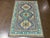 Hand-knotted Pakistani Kazak wool rug featuring a blue-gray field with three geometric medallions arranged vertically. The...