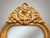 A super long and slender French-inspired gilt wood mirror featuring an elegant arched top topped with an ornate carved...