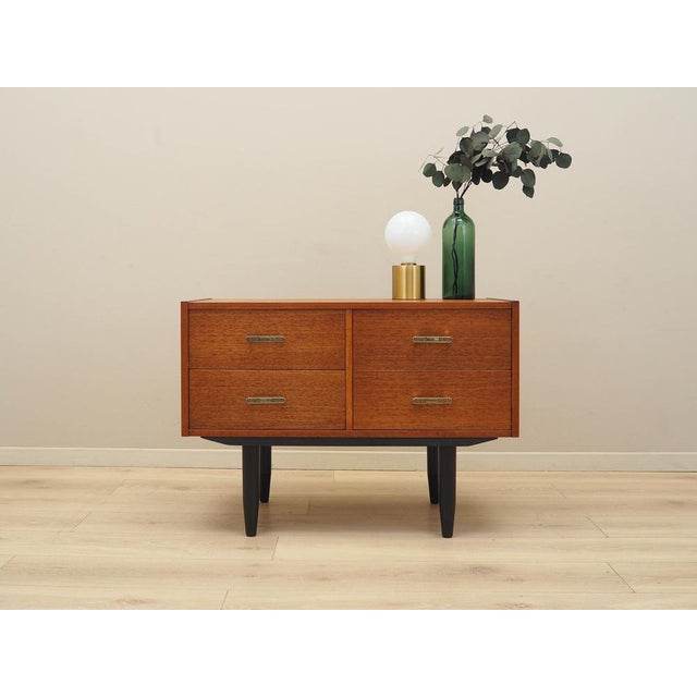 The chest of drawers was made in the 1970s in Denmark. The structure is covered with teak veneer. The legs are made of...
