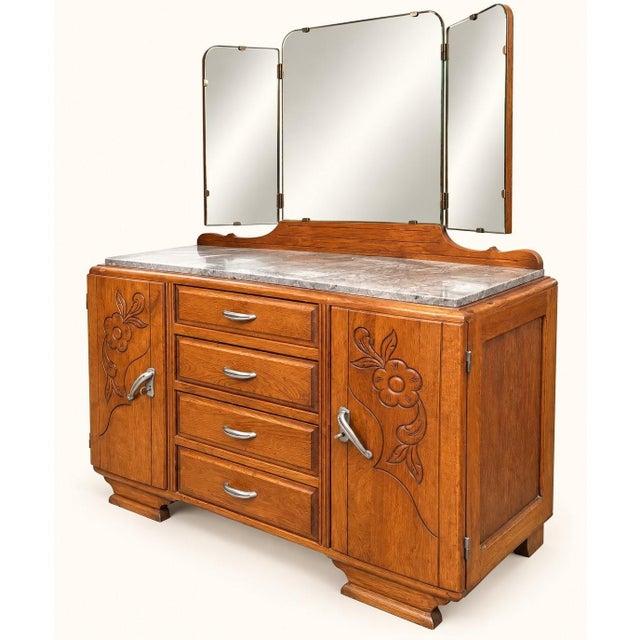 A 1930s art deco dressing table in solid oak with a pronounced grain, featuring the wide, squat silhouette characteristic...
