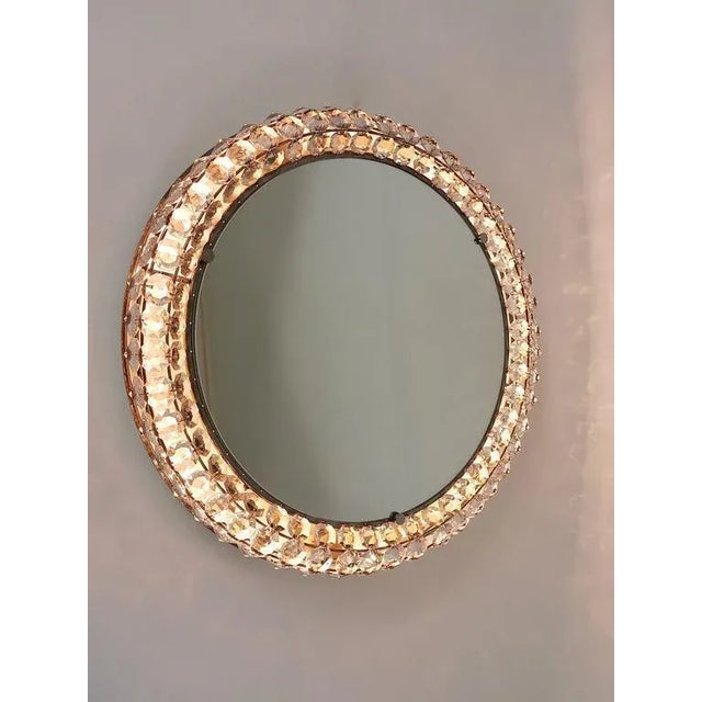 A beautiful round Mid-Century wall mirror with a frame covered with three rows of diamond-shaped faceted crystals....