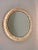 A beautiful round Mid-Century wall mirror with a frame covered with three rows of diamond-shaped faceted crystals....