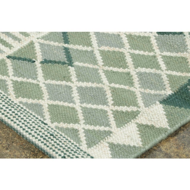 Handwoven in wool, this 5x7 Scandinavian rug showcases layered geometric motifs in sage green and ivory, balancing...