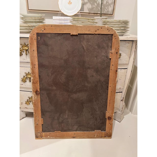 A charming 19th century French Louis Philippe mirror with a richly curved gilded frame adorned with delicate floral...