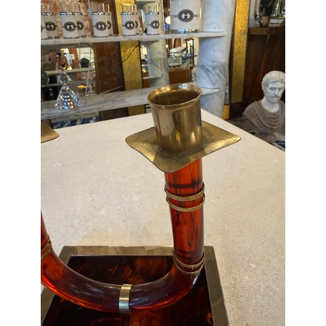 Sculptural Italian double candlestick from the 1970s, crafted in richly patterned tortoiseshell lucite with polished brass...