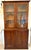 Antique Victorian quality figured mahogany bookcase having a shaped cornice above a pair of mahogany glazed doors opening...