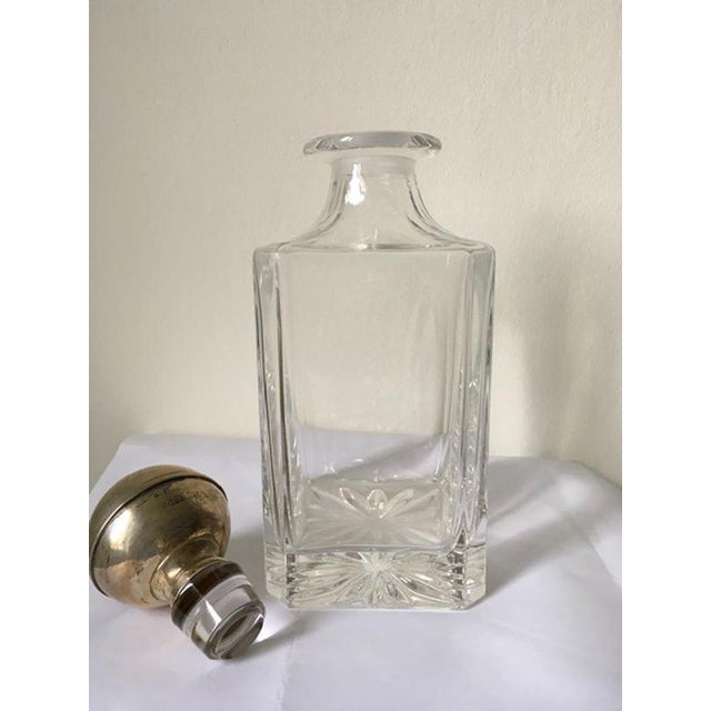 This an elegant whiskey crystal bottle.The crystal stopper is coated in silver. The surface in silver shows the signs of...