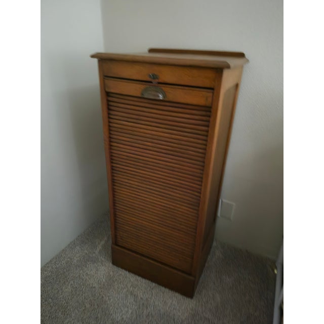 This is an antique oak tambour filing cabinet from the early 20th century, likely dating between 1880 and 1920. It...