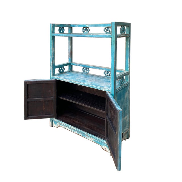 This is an oriental small display cabinet made of elm wood and finished in distressed pastel blue #3DACC7 color. It is...