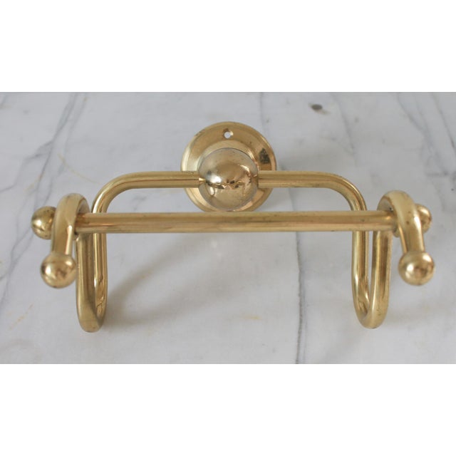 Vintage brass toilet paper holder. No makers mark. Some age wear to finish. Includes hardware.