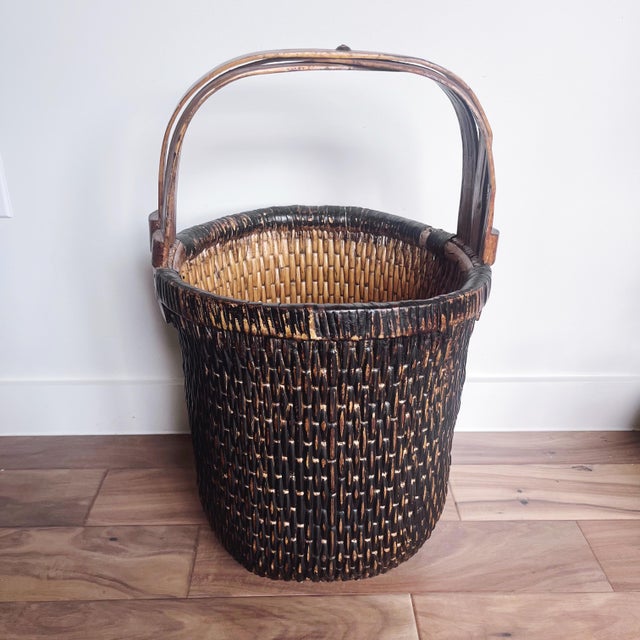 Antique Chinese woven fisherman’s rattan and cane basket with bent handle. This basket was handmade in the mid 1800s in...