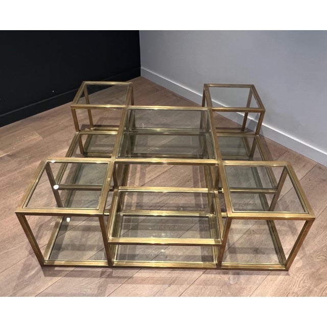 This beautiful and very interesting multi-tiered coffee table is made of brass with glass shelves. It is a French work....