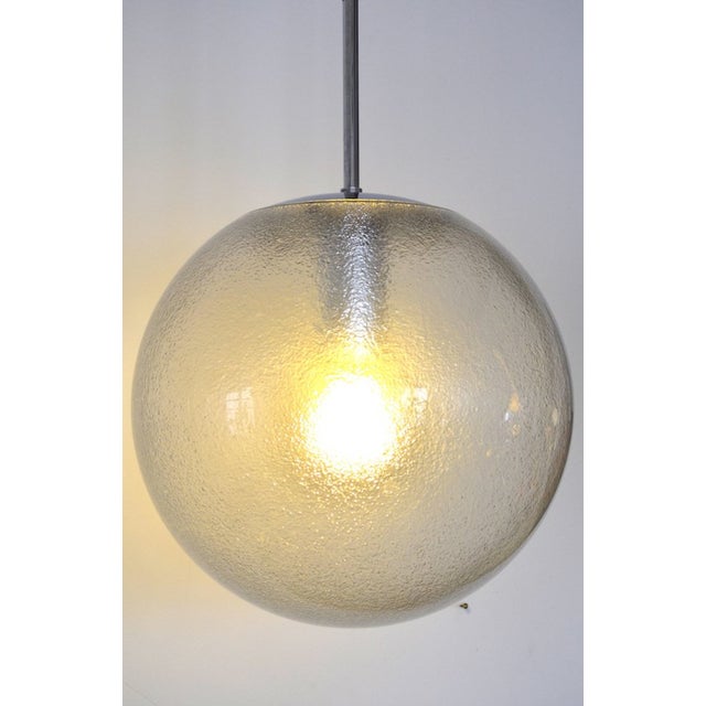 Beautiful spherical pendant light from the limburg glassworks. the light is very well made and features a chrome fitting...