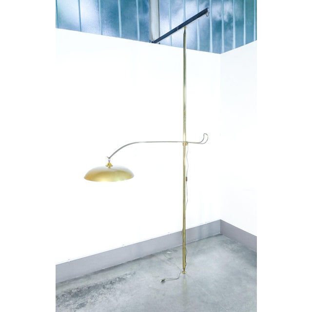 Lamp with adjustable arm mounted on a floor-to-ceiling brass rod. Italian design from the 1940s origin italy period 1940s...