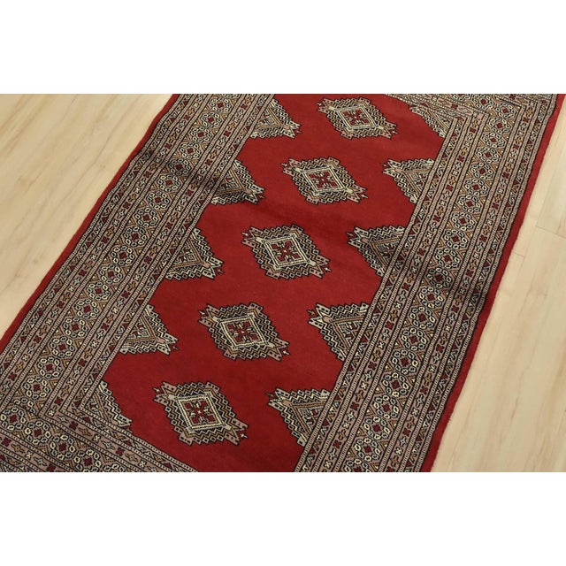 A tribal Bokhara Jaldar rug hand-knotted with fine wool on a cotton foundation. This rug features geometric medallions set...