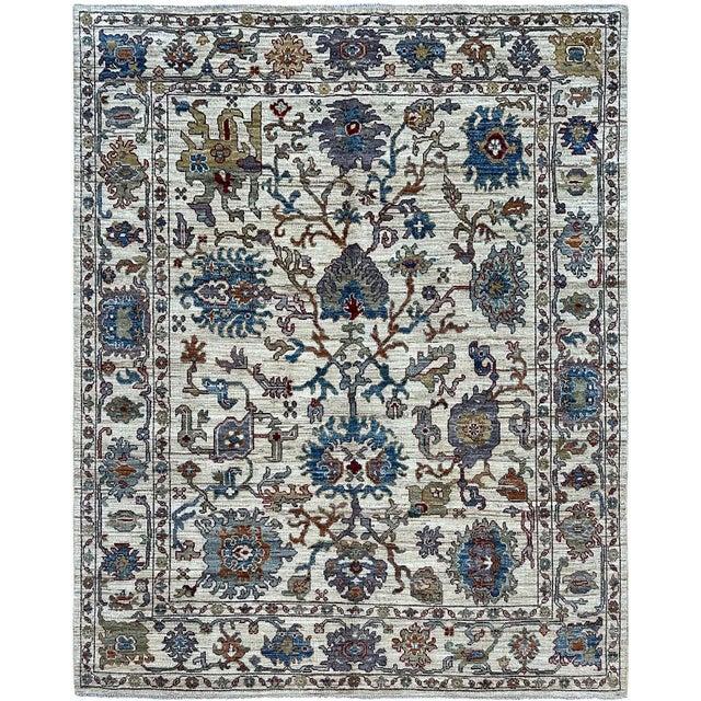 Large blue and lavender-gray blossoms connect through branching rust-brown vines across the ivory field of this handmade...