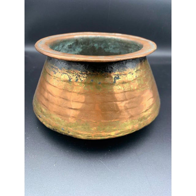 The Antique Hand Forged Omani Bedouin Copper Pot is a unique and intriguing piece that measures 7 1/2" x 3 1/2". This pot...