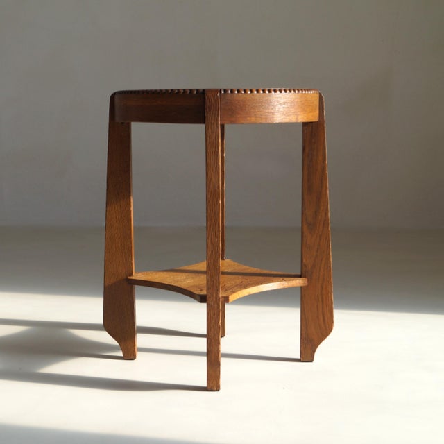 A Dutch Art Deco oak side table from the 1920s, modest in scale yet rich in presence. Its circular top is encircled by a...