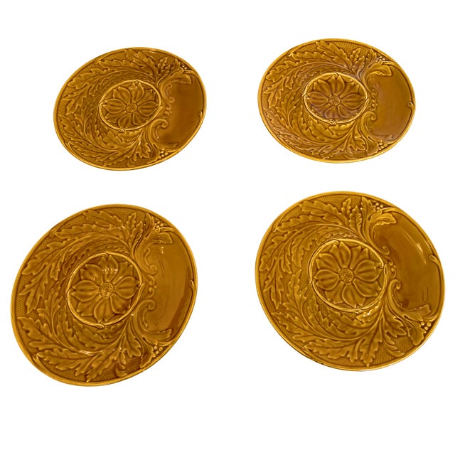 A beautifully sculptural set of four Gien majolica artichoke plates, glowing in a rich honey-amber glaze and adorned with...