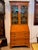 Astragal glazed doors above open to shelves painted a soft green, and the fall front below drops to a fitted interior of...