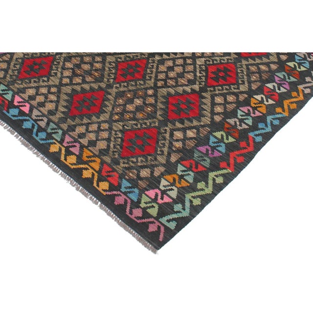 Add a touch of elegance to your home with this casual chic hand woven Tribal Kilim wool rug. Constructed on a loom by...