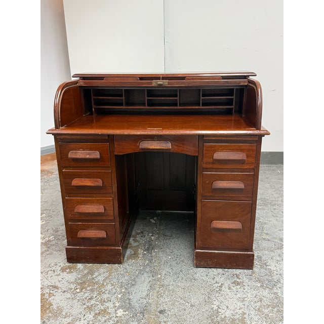 Design Plus Gallery presents a Victorian Lebus Manner Oak Roll Top Desk. It has a traditional paneled construction and a...