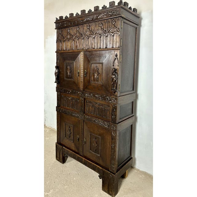 Impressive monumental oak cabinet standing approximately 2 meters high, richly carved in the Gothic Revival taste. The...