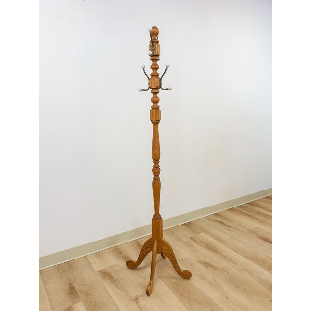 This elegant vintage brass and wood coat rack with porcelain cream knobs is a refined and characterful entryway find. The...