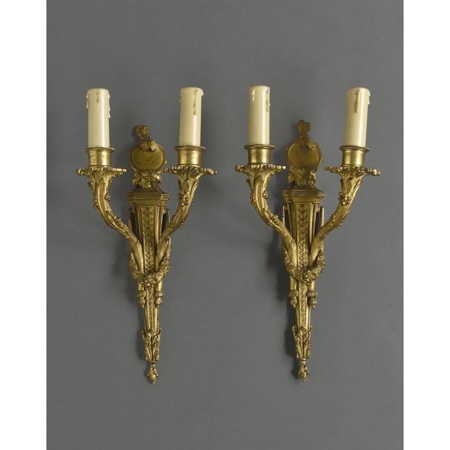 After Jean-Charles Delafosse (1734-1791). Pair of Louis XVI gilt bronze wall sconces For Sale