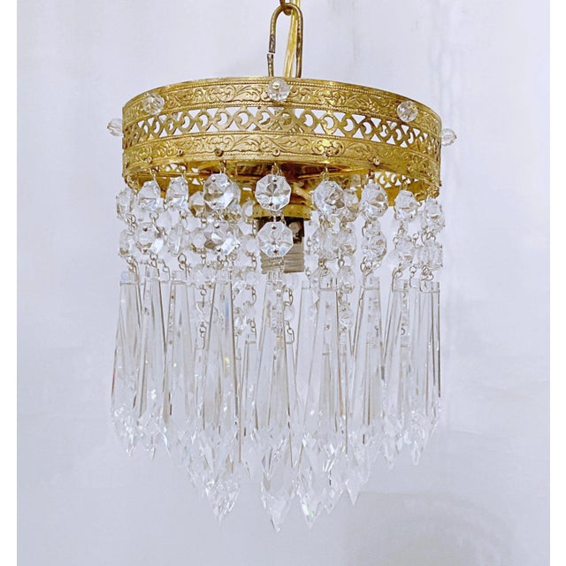 This is an Italian brass rim chandelier dressed with octagon chain and Strauss plug cut crystals drops. It has 1 Edison...