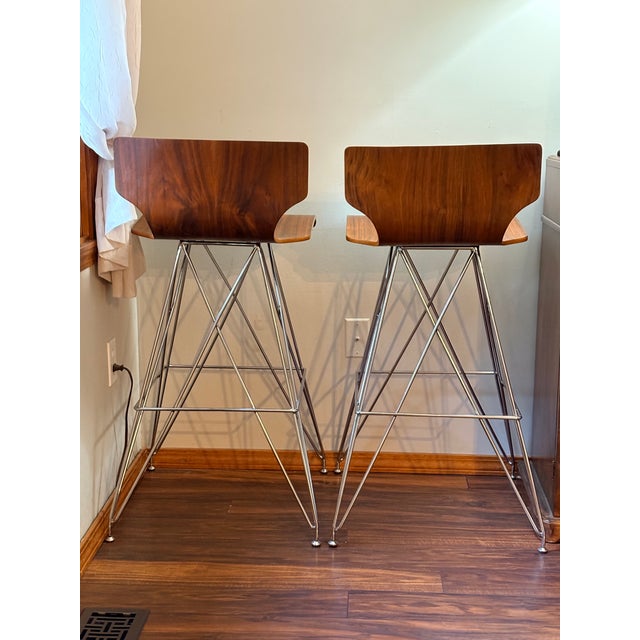 Pair of bentwood seat bar stools with figured teak veneer, low backs and chromed steel "Eiffel Tower" like bases....