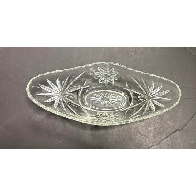 This elegant vintage oval dish is crafted in clear American pressed glass and features a refined starburst and fan motif...