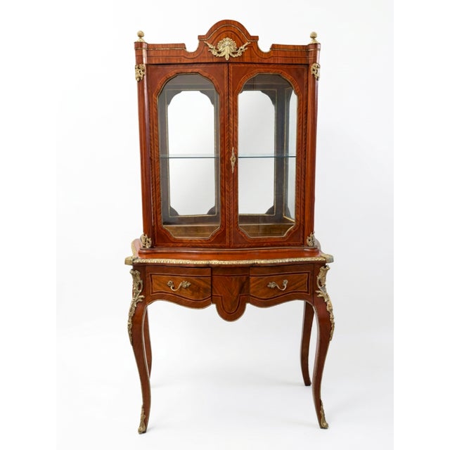 An exquisite French Louis XV style vitrine cabinet (display cabinet on stand), crafted with exceptional artistry. This...
