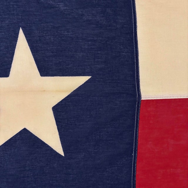 This vintage Texas flag is made from a thin cotton cloth with printed star and sewn panels. Please note staining, small...