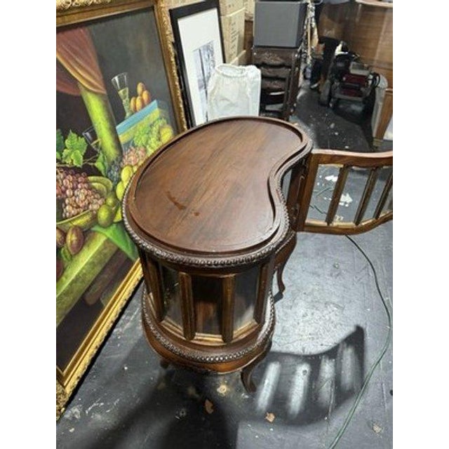 This Kidney Shaped Tea/Liquor Cabinet Table is a unique and elegant piece of antique furniture. With a beveled glass top...