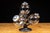 Countertop merchandising display featuring four spherical clear glass storage jars mounted on a revolving metal stand. The...