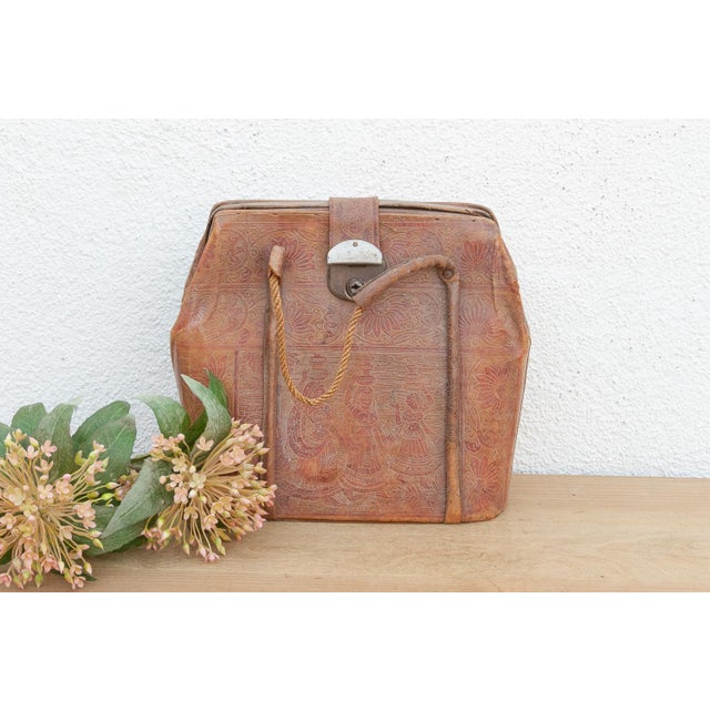 A nostalgic piece of mid-century handcraft, this satchel showcases the art of Indian leather tooling. The leather has been...