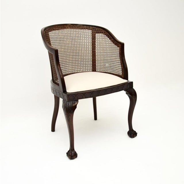 A beautiful antique Edwardian caned armchair, made in England and dating from around the 1900-1910 period. This is of...