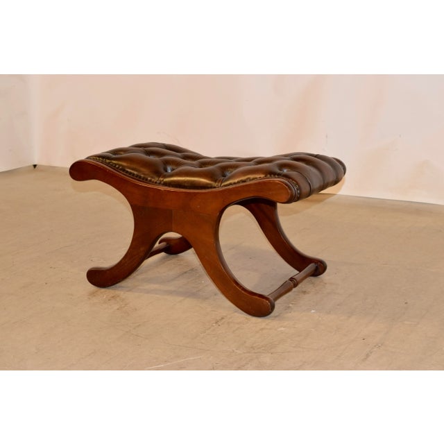 English mahogany stool with a Chesterfield upholstered leather top in rich brown with leather welt decoration, circa 1920.