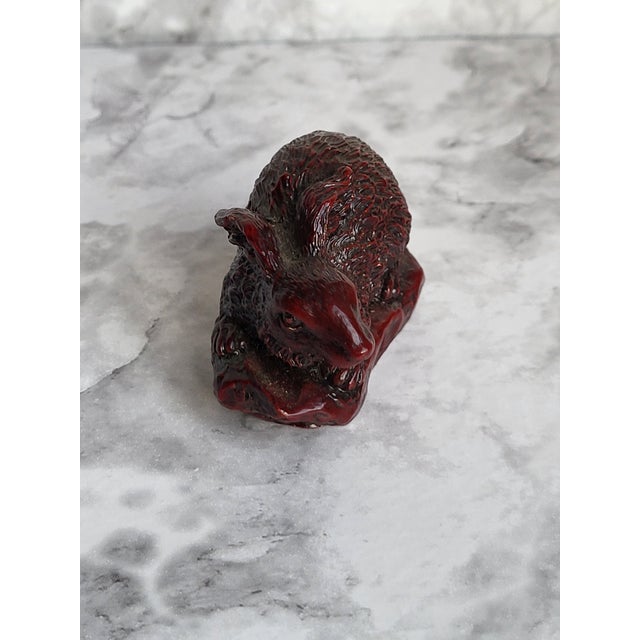 Japanese netsuke carved out of wood with a reddish stained finish. This chubby rabbit appears to be circa mid-20th century.