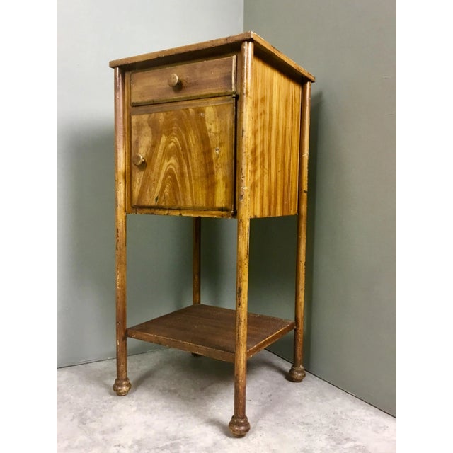 This handmade iron nightstand is painted to give the appearance of wood.