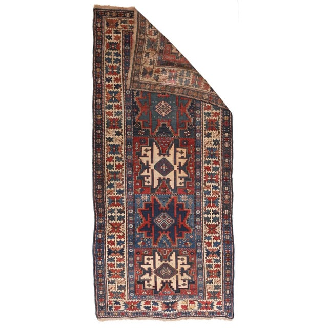 This east Caucasian Kellegi hosts a paneled light, medium and dark blue, and red field with five eight pointed "Lesghi...