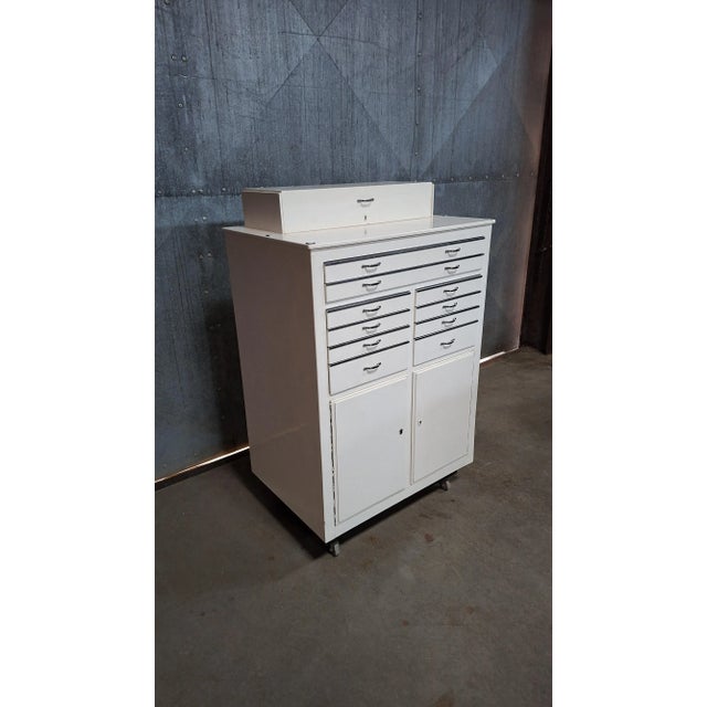 Rare wooden dental cabinet on wheels, a mid-century medical piece you don’t often find. While most are metal, this version...