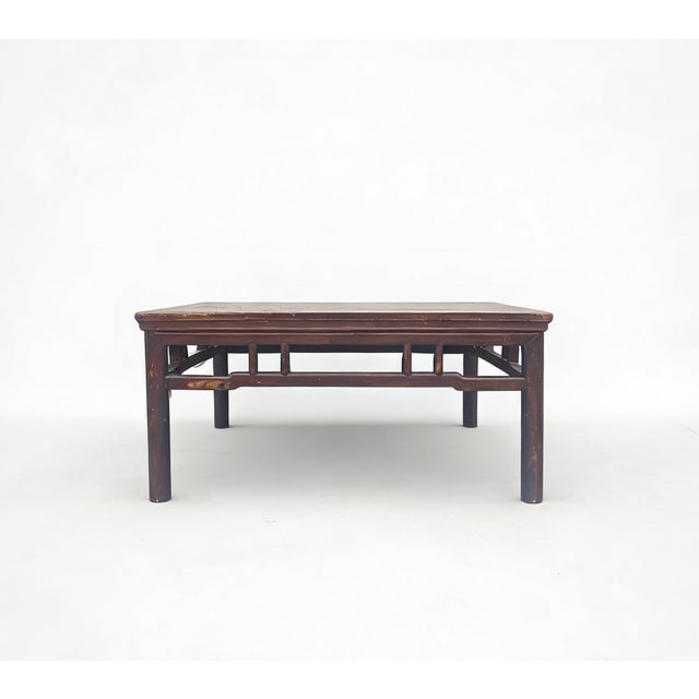 This antique square table features a low-profile design traditionally used on elevated living platforms. Constructed from...