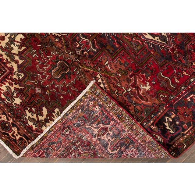 The Antique Persian Heriz rug is a stunning handmade piece crafted from high-quality wool. Its rich red background...