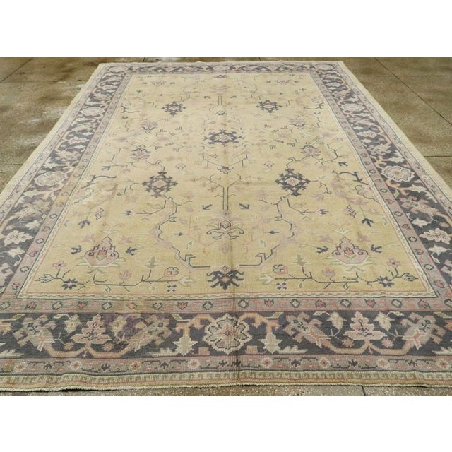 An antique Turkish Oushak room size carpet. This mellow-toned western Turkish workshop room size carpet has a straw yellow...