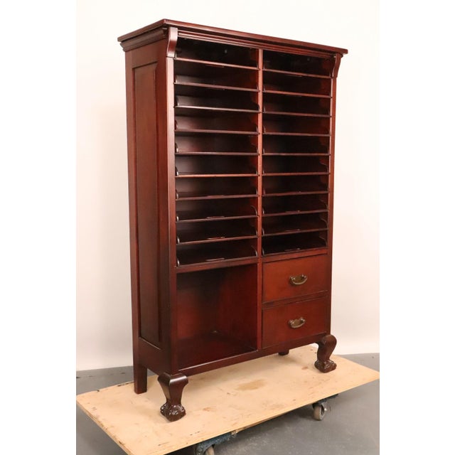 Antique music sheet cabinet made of dark stained mahogany with the original brass hardware. It features twenty-four...